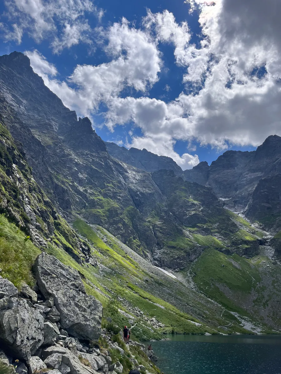 Green slopes rising over a dark mountain lake